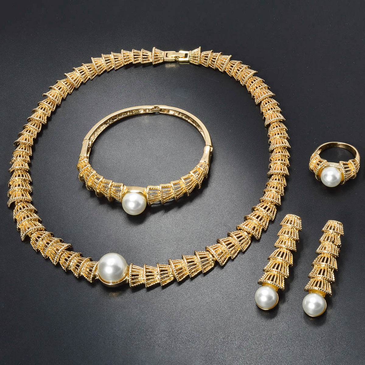 Set di quattro gioielli vintage in oro con perle traforate