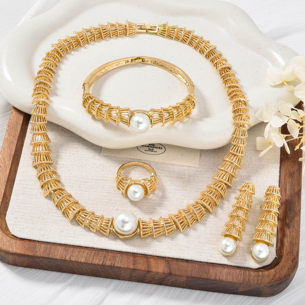 Set di quattro gioielli vintage in oro con perle traforate