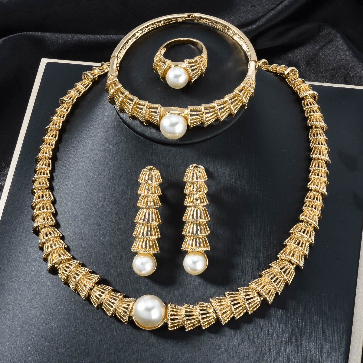 Set di quattro gioielli vintage in oro con perle traforate